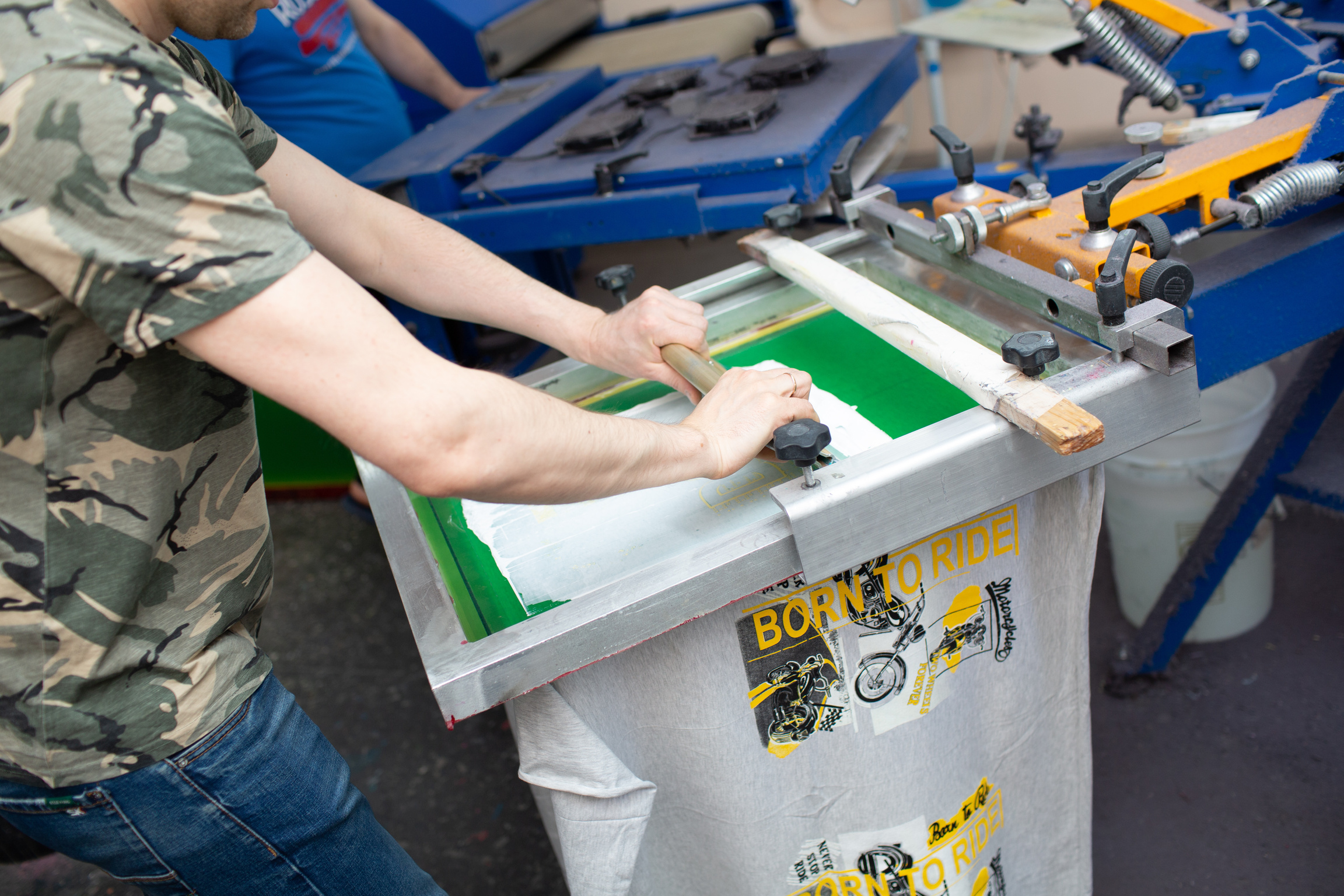 Serigraphy Silk Screen Print Process at Clothes Factory. Frame, Squeegee and Plastisol Color Paints